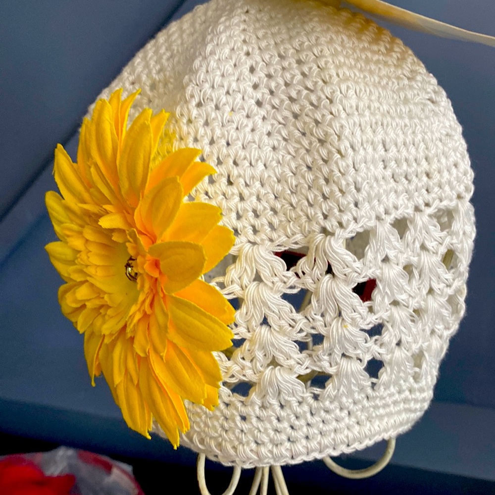 Crochet hat with yellow blooming flower